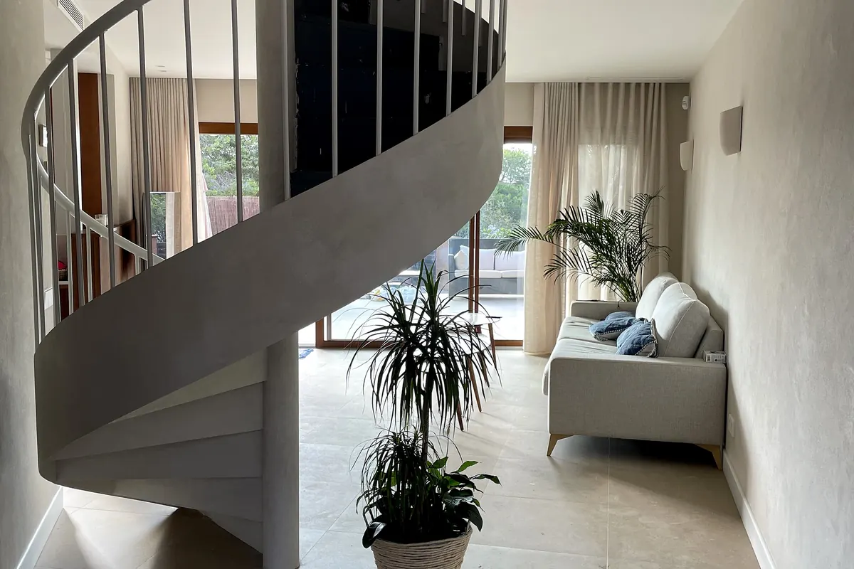 Escalera helicoidal revestida en MicroStone con paredes de cal