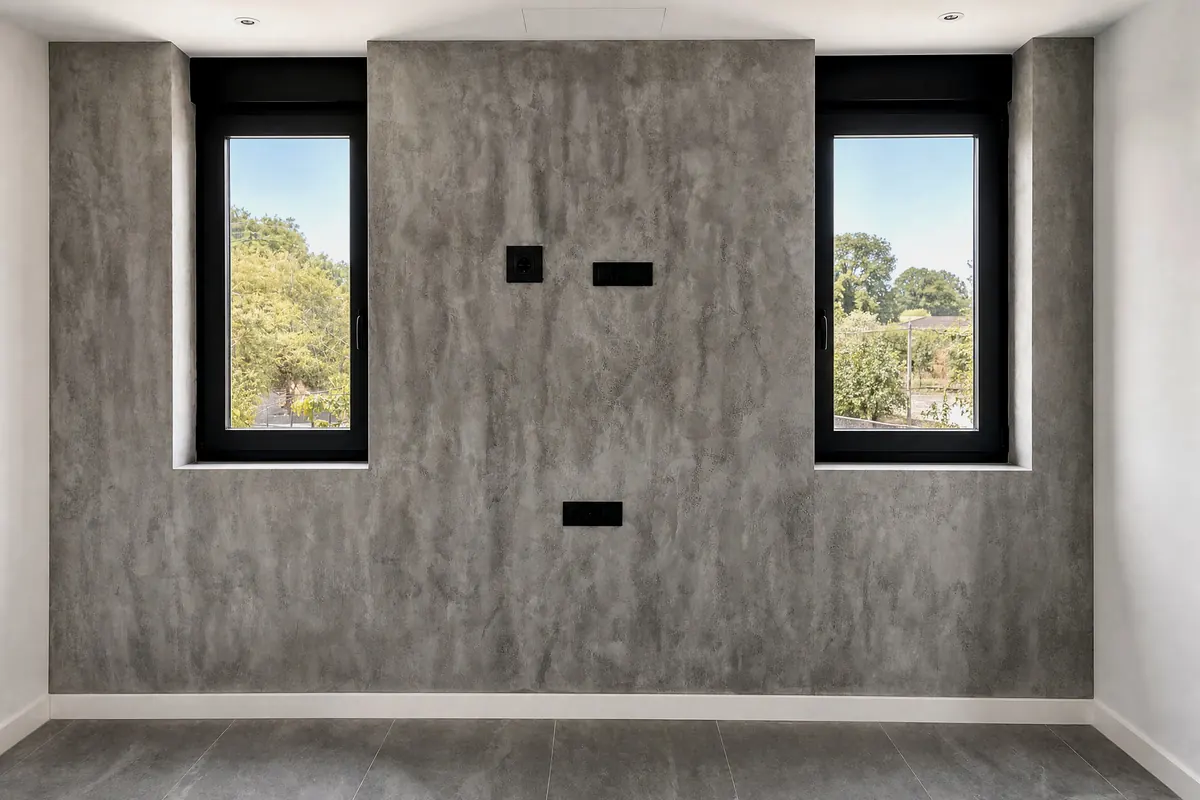 Pared de microcemento efecto hormigón entre dos ventanas